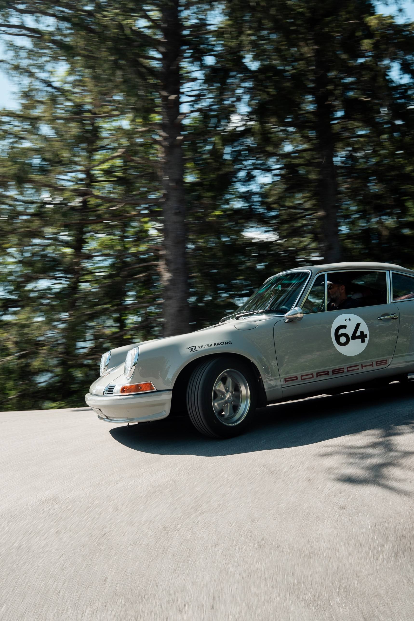 Klassischer grauer Porsche 911 mit Startnummer 64 auf einer Waldstraße