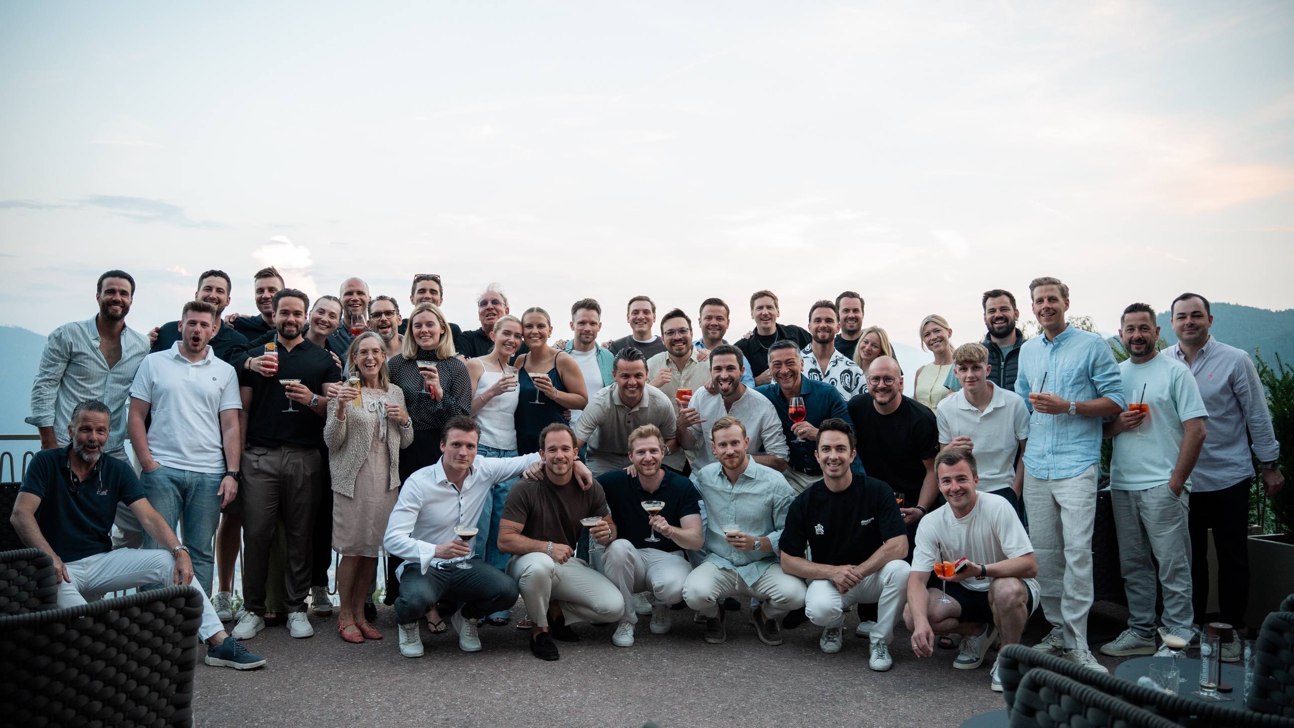 Gruppenfoto am Abend mit Getränken auf einer Terrasse