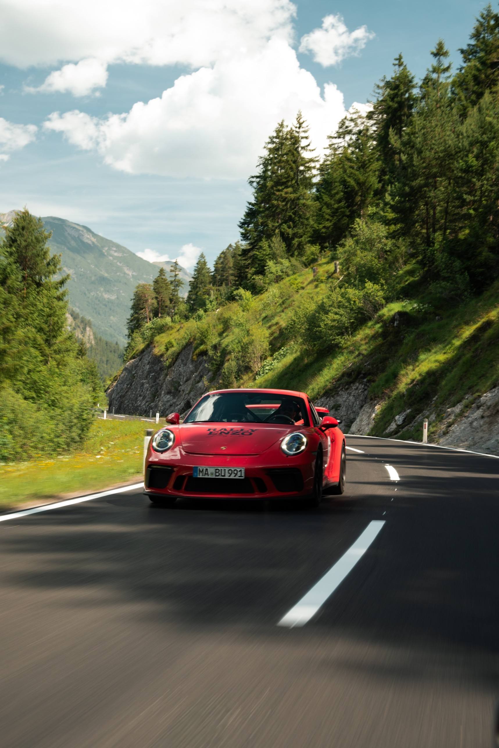 Roter Porsche 911 GT3 mit RALLY-ENZO-Beklebung in einem Alpental