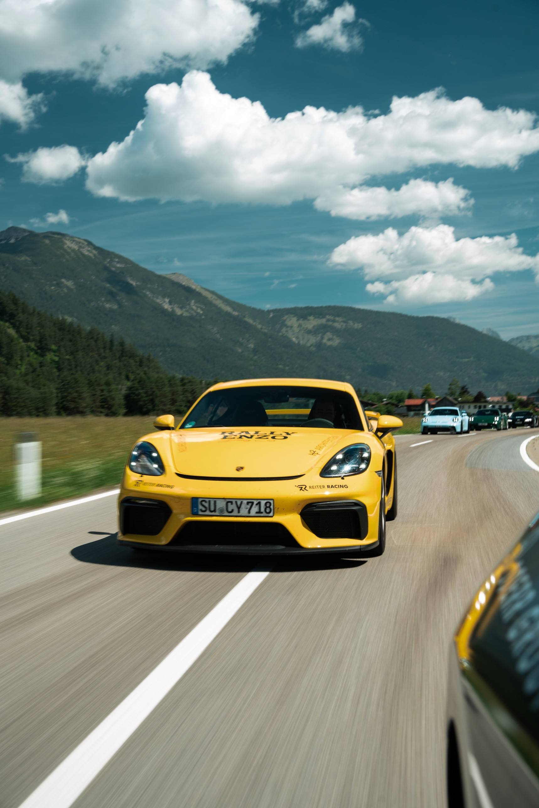 Schwarzer Audi R8 und roter Porsche 911 in einer Kurve an einer Felswand